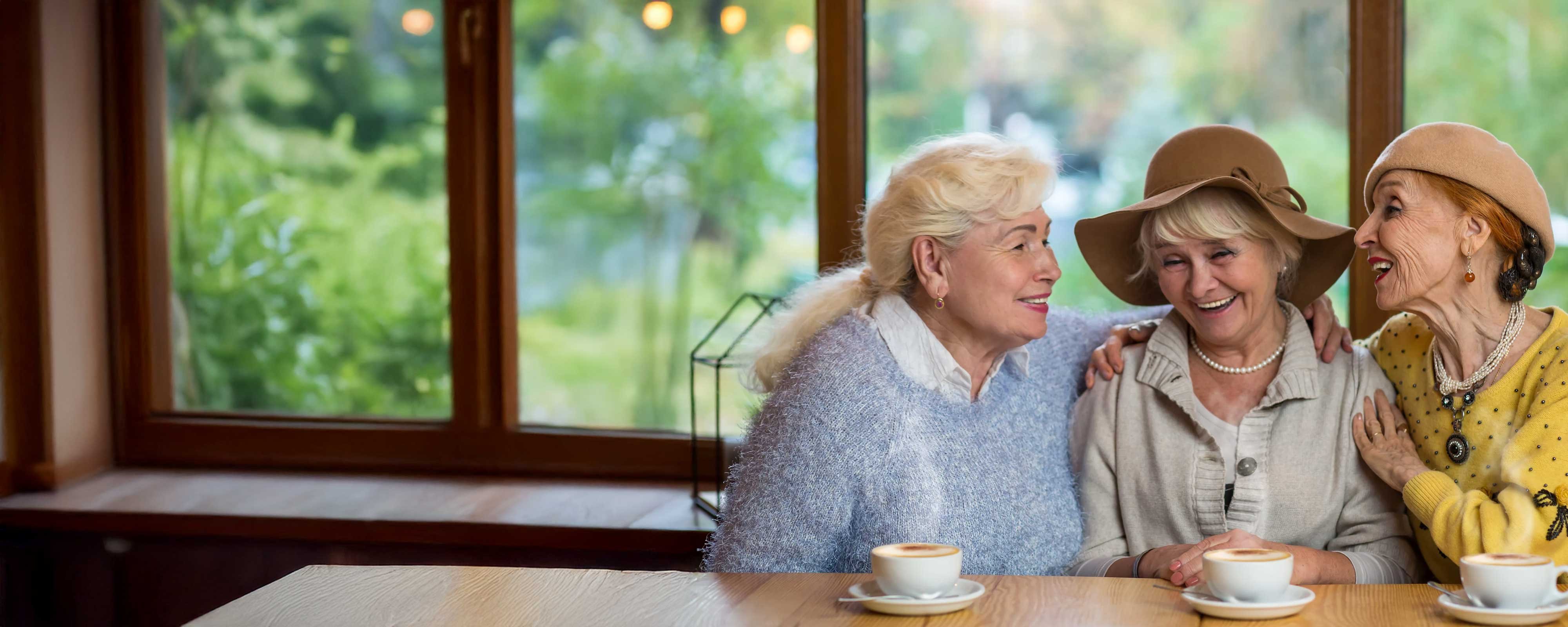 Three ladies enjoying a discussion and drinking.